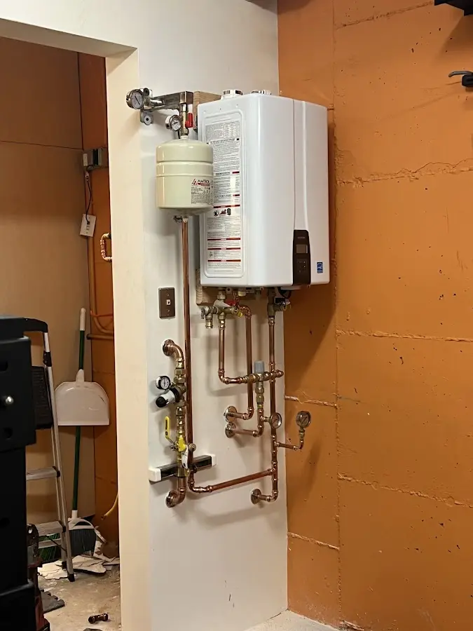 Plumbing technician inspecting water heater connections in Pace